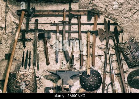 Mittelalterliche Waffen auf einen weißen Stein Wand. Cooler Hintergrund. Stockfoto