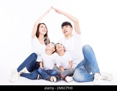 Glückliche Familie, die mit ihren Händen ein Hausdach bildet. Versicherungskonzept Stockfoto