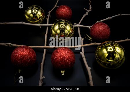 Weihnachtlicher Tic-tac-Zeh mit rot-goldenen Dekorationen. Stockfoto