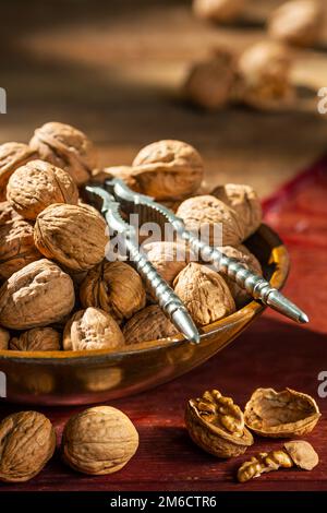 Stillleben mit Walnüssen in einer Holzschüssel auf einem Tisch Stockfoto