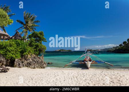 Traditionelles philippinisches Doppelauslegerboot, auch bekannt als bangka, banca und Paraw, in einem makellosen Weiß Stockfoto