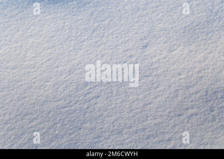 Hintergrund von weißem Schnee, der in der Sonne glitzert. Geringe Schärfentiefe Stockfoto