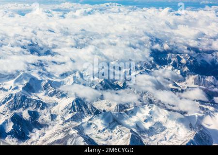 Blick auf die Berge vom Flugzeugfenster während des Fluges Stockfoto