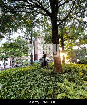 Riverside Park, NY, 9. September 2022 - Eleanor Roosevelt Monument, inmitten von Bäumen, Vogel auf dem Kopf, Sonnenschein durch Bäume. Künstler - Penelope Jencks. Stockfoto