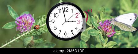 Sommerzeit. DST. Wanduhr geht auf Winterzeit. Dreh die Zeit vorwärts. Stockfoto