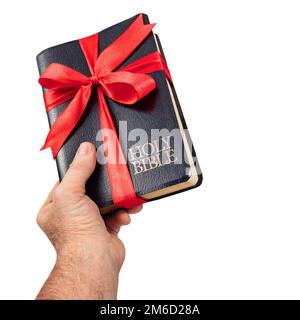 Die Hand, die das Geschenk der Heiligen Bibel überreicht Stockfoto