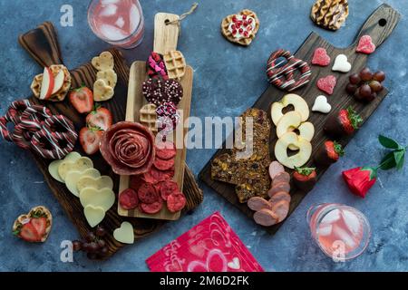 Charcuterie Boards am Valentinstag mit Käse, Fleisch und Süßigkeiten. Stockfoto