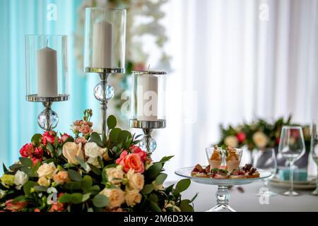 Kerzen und Blumen auf einem festlichen Tisch Stockfoto