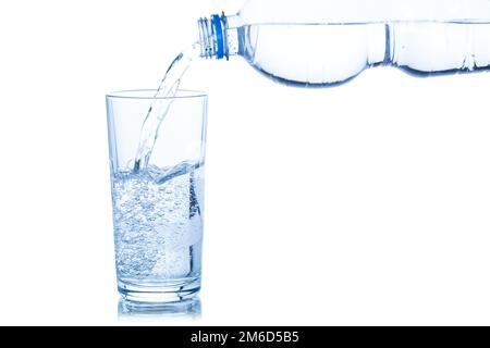 Wasser fließt in eine weiße, isolierte Glasflasche Stockfoto