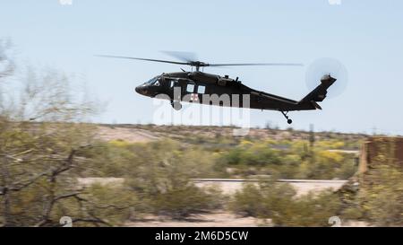 Ein Arizona Army National Guard UH-60L Black Hawk Helikopter, der dem 2-285. Attack Helicopter Bataillon in Phoenix zugeteilt wurde, fährt bei einer Rettungsübung am 23. April 2022 im Florence Military Reservation in Florence, Ariz, tief durch die Sonora-Wüste (Arizona Army National Guard Foto von Sergeant 1. Klasse Brian A. Barbour) Stockfoto