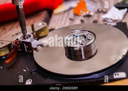 Ein Mann zerbricht einen Computer mit Schlosser. Stockfoto