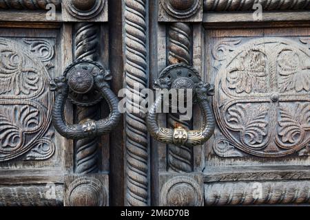 Wunderschöne alte Holztür mit eisernen Ornamenten in einer orthodoxen Kirche, Detail des alten Knockers auf dem Do Stockfoto