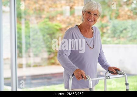 All die Unterstützung, die ich für ein aktives Leben brauche. Porträtaufnahme einer Seniorin mit einem orthopädischen Geher, positiv aussehend. Stockfoto