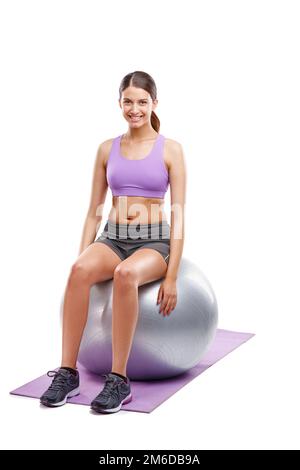 Das einzig schlechte Training war das, das nicht stattgefunden hat. Eine schöne junge Frau, die Übungen auf ihrem Fitnessball macht. Stockfoto