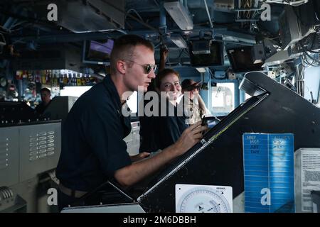 PHILIPPINISCHE SEE (24. April 2022) Seeleute stehen im Pilotenhaus an Bord des Schiffs USS Mobile Bay (CG 53) der Ticonderoga-Klasse Wache. Die Abraham Lincoln Strike Group befindet sich in einem geplanten Einsatz im US-7.-Flottenbereich, um die Interoperabilität durch Allianzen und Partnerschaften zu verbessern und gleichzeitig als einsatzbereite Truppe zur Unterstützung einer freien und offenen Region Indo-Pacific zu fungieren. Stockfoto