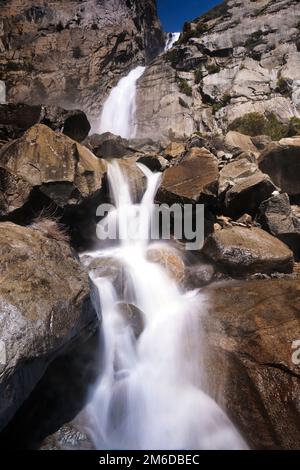 Die Landschaft des Wapama Wasserfalls, der über Felsen stürzt und zum Hetch Hetchy Reservoir im Yosemite-Nationalpark fällt. Stockfoto