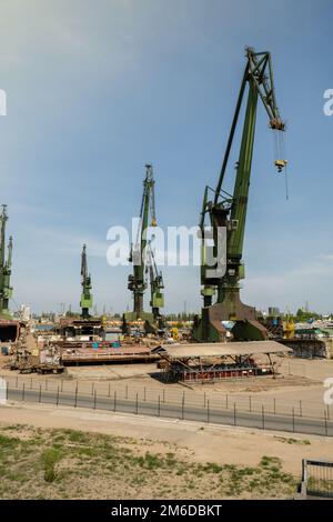 Industriegebäude in der Danziger Werft, ehemalige Lenin Werft, Vorfertigungswerkstatt und schwere Kräne große polnische Werft. Krane auf der historischen Werft in Danzig Hauptsitz der Solidarity Polska Stockfoto