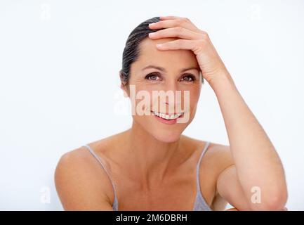 Sie trägt ihre Schönheit ins mittlere Alter. Porträt einer schönen, reifen Frau, die im Studio posiert. Stockfoto