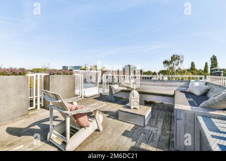 Ein Dach mit einigen Möbeln und dem Himmel im Hintergrund ist hellblau, aber keine Wolken sichtbar Stockfoto