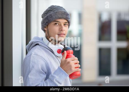 Sportlich trainierter junger latino, der Emotionsläufer denkt, der Kopierraum aufsucht Stockfoto