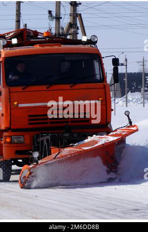 Ein großer LKW räumt Schnee von der Straße. Stockfoto