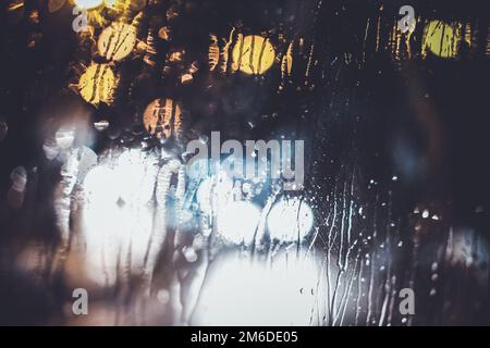 Ampel durch das Fenster in einer regnerischen Nacht Stockfoto