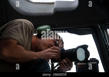 Matthew Plew, ein Luftkampfkamerahandwerker der 1st Combat Camera Squadron, dokumentiert am 24. April 2022 einen Flug über dem US Central Command Area of Responsibility. Das 1. CTCS erwirbt Fotos und Bewegungsbilder zur Unterstützung klassifizierter und nicht klassifizierter Luft-, See- und Bodenoperationen als grundlegendes Werkzeug für Kommandanten und Entscheidungsträger im gesamten Verteidigungsministerium. 1 CTCS, 557. Expeditionary Redhorse Squadron, 816. Expeditionary Airlift Squadron, Airlift, C-17 Globemaster III, Stockfoto