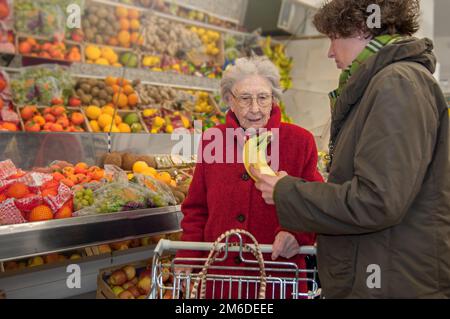Pflegekraft mit Seniorin im Supermarkt Stockfoto