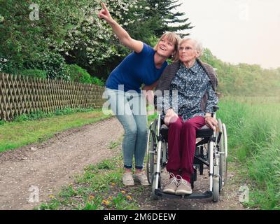 Seniorin mit junger Pflegekraft im Park Stockfoto