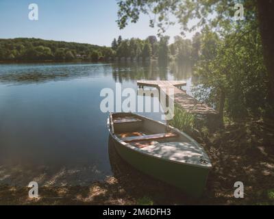Boot auf dem Peer eines ruhigen Sees im Sommer Stockfoto
