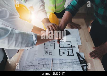 Architekten, die mit Bauplänen arbeiten. Bauingenieurteams, die zusammenarbeiten. Teamarbeit von Projektmanagern in der Foreman Industry Stockfoto