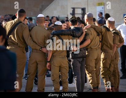 Jerusalem, Israel. 19. Dezember 2022. Eine Gruppe israelischer Soldaten posiert auf dem Tempelberg in Jerusalem in der Nähe der Klagemauer mit einem jungen Mann, der auch eine Kippah trägt. Kredit: Frank Rumpenhorst/dpa/Frank Rumpenhorst/dpa/Alamy Live News Stockfoto