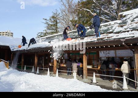 Hokkaido, Japan - 21. Dezember 2022 : Arbeiter führen Schneeräumarbeiten am Hokkaido-Schrein in Sapporo, Hokkaido, durch Stockfoto