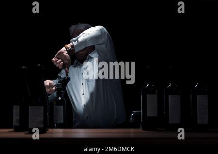 Der Mann öffnet Flaschen Wein Stockfoto