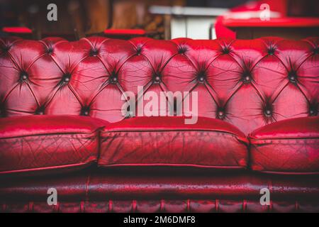 Leeres rotes Sofa im gemütlichen Wohnzimmer, altmodische Oldtimer-Stilmöbel Stockfoto