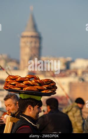 Ein türkischer Mann trägt Simit auf einem Tablett auf dem Kopf auf den Galataturm, Istanbul, Türkei Stockfoto