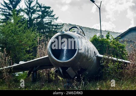 Der alte vernachlässigte russische Flugzeugjäger MIG-17 auf der Dorfwiese Stockfoto