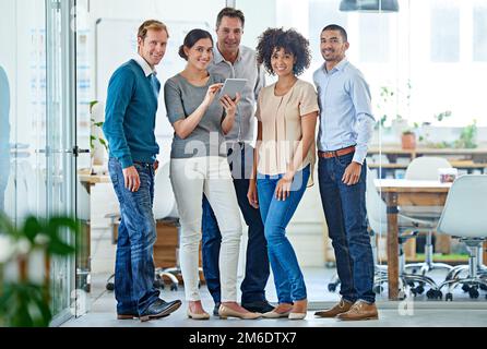 Professionell und positiv. Porträt einer vielfältigen Gruppe von Kollegen, die in einem Büro stehen. Stockfoto