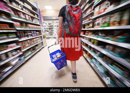 Das Dateifoto vom 03. Oktober 09/22 zeigt einen Käufer, der durch den Gang eines Tesco Supermarkts läuft, während die Nahrungsmittelinflation auf Rekordniveau gestiegen ist, da viele Haushalte aufgrund steigender Preise ein „herausforderndes Weihnachten“ erlitten, neuen Zahlen zufolge. Stockfoto