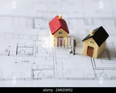 Geschäftsmann-Miniatur und Hausminiatur auf Innenzeichnung Stockfoto