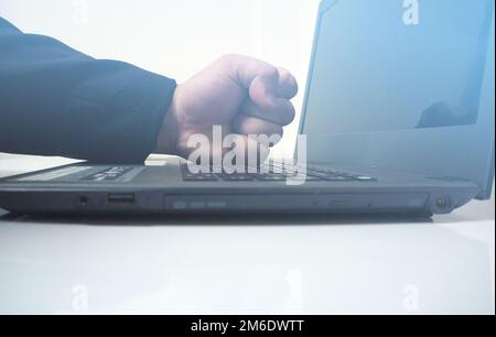 Probleme von Laptops bei der Arbeit. Büro von der Arbeit verärgert. Fäuste zerschlagen Computer Stockfoto