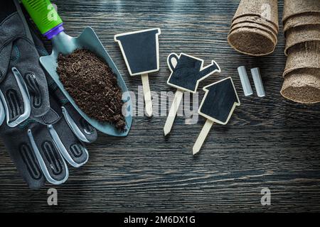 Gartenarbeit Handspaten Erde Torftöpfe Schutzhandschuhe Kreidetafel Schilder. Stockfoto