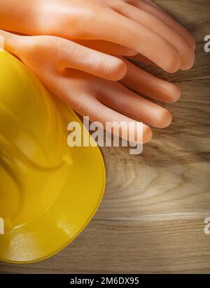 Isolierhandschuhe Schutzhelm auf Holzbrett. Stockfoto