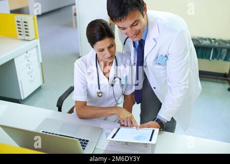 Die Beweise deuten darauf hin, dass es ihnen besser gehen sollte. Ein medizinisches Team, das eine Patientenakte durchsucht. Stockfoto