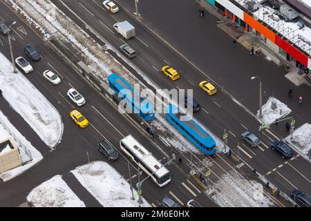 Kreuzungen der Stadt mit verschiedenen Fahrzeugen, Straßenbahnen und Bussen, Autos und Fußgängern bewegen sich entlang des Touary der Straße. Luftaufnahme Stadtstraße Stockfoto