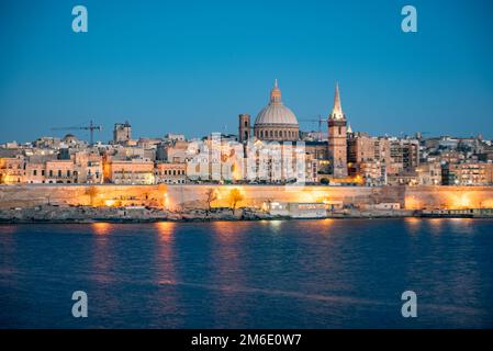 Panoramablick auf die Skyline von Valletta bei schönem Sonnenuntergang von Sliema mit den Kirchen unserer Lieben Frau von Moun Stockfoto