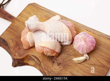 Rohe, ungekochte Hühnerschenkel mit Knoblauch Stockfoto