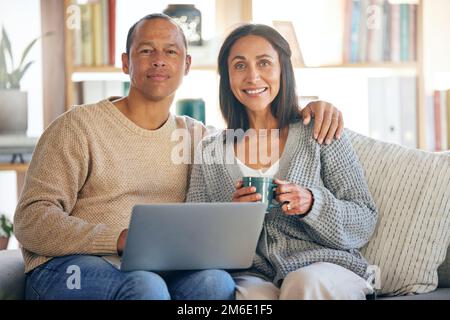 Liebe, Laptop und Porträt eines Paares Entspannen Sie sich auf dem Sofa im Wohnzimmer, trinken Sie Kaffee und arbeiten Sie von zu Hause aus. Digitaler Computer, Tee und ein Mann, der freiberuflich schreibt Stockfoto