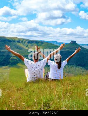 Ein paar Männer und Frauen mit Händen oben in den Bergen des Drakensberger Riesenschlosses Südafrika, während einer Wanderung in den Bergen im Sommer Stockfoto