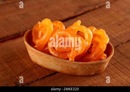 Indian Sweet Jalebi in einer handgefertigten Töpferschale auf Holzhintergrund Stockfoto